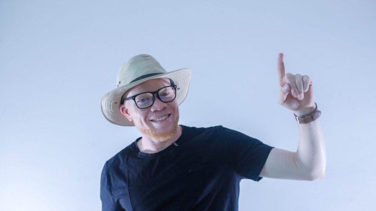man in black crew neck t-shirt wearing green hat and eyeglasses