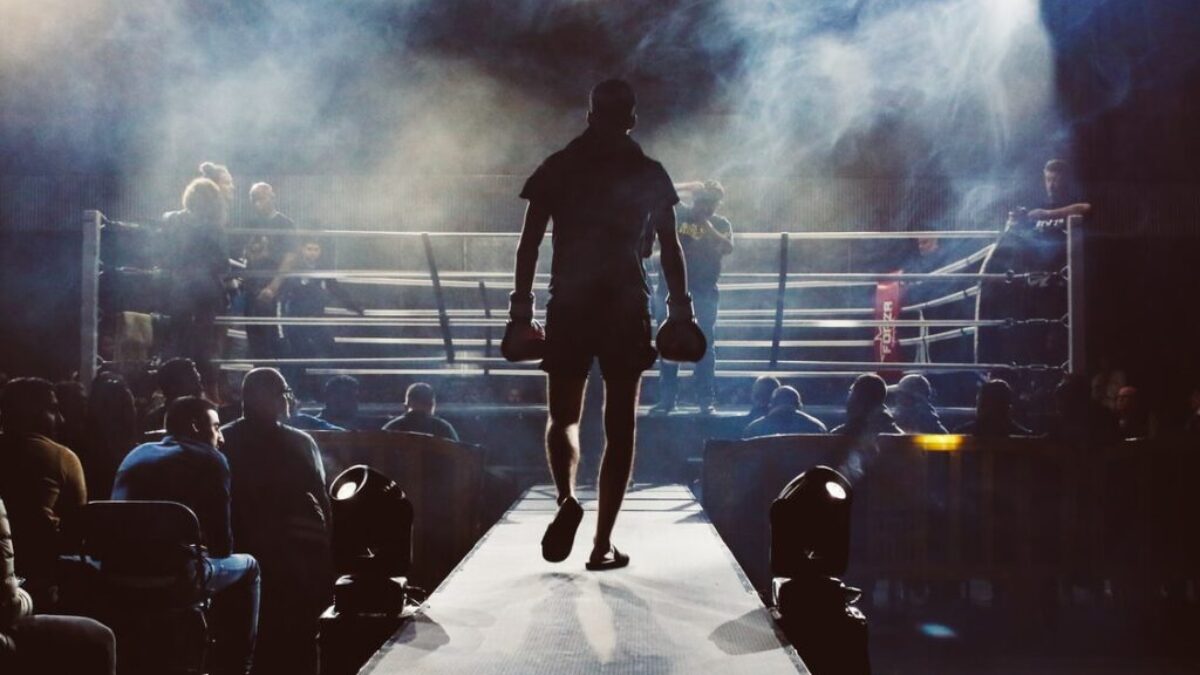 man standing and walking going on boxing ring surrounded with people