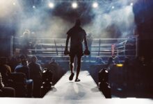 man standing and walking going on boxing ring surrounded with people