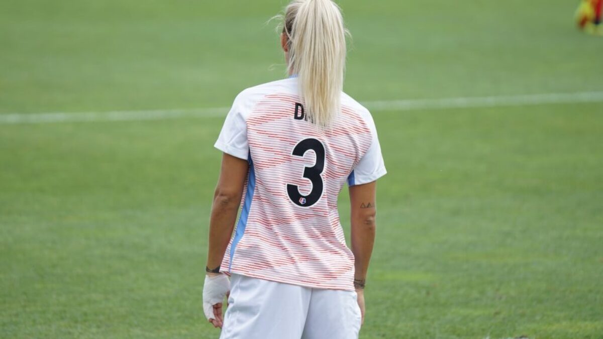 female soccer player standing at field