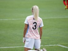 female soccer player standing at field