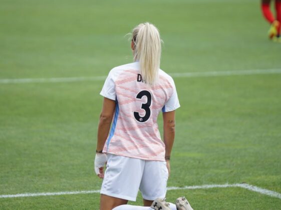 female soccer player standing at field