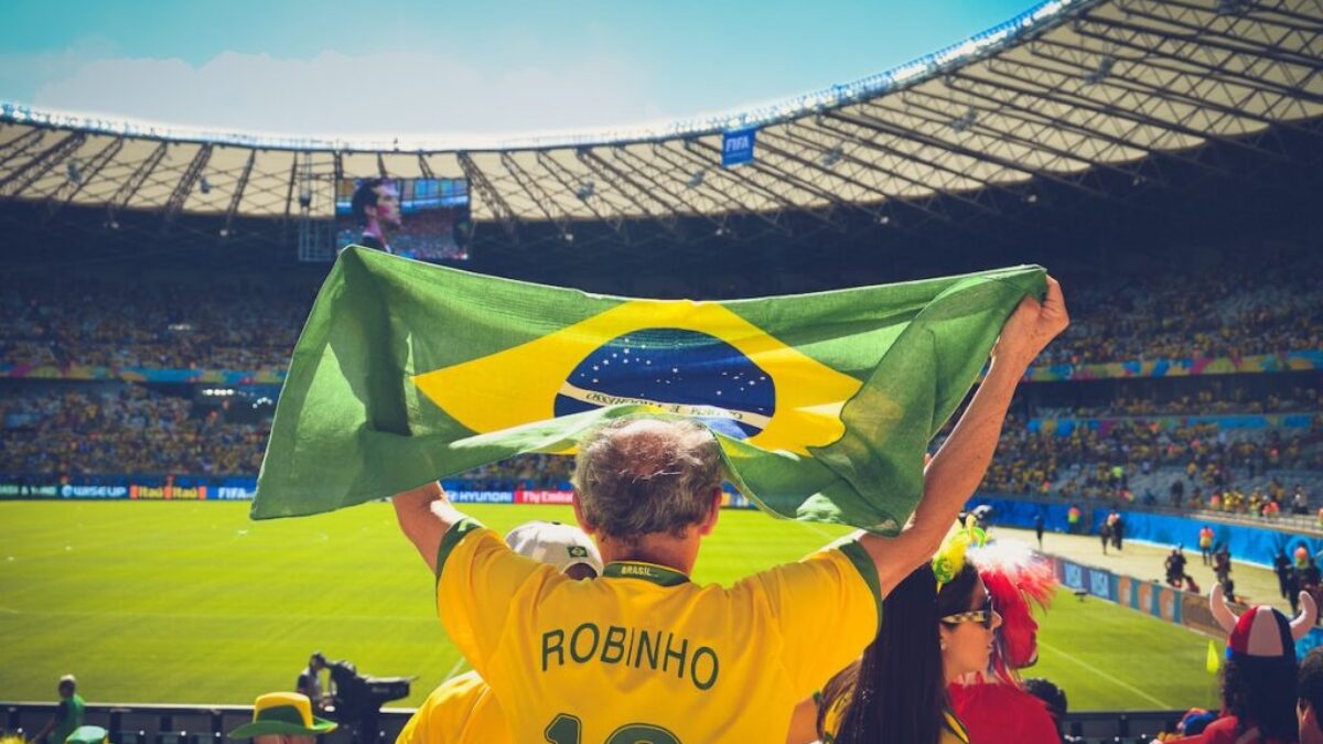 Man Raising Brazil Flag Inside Football Stadium