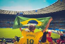 Man Raising Brazil Flag Inside Football Stadium