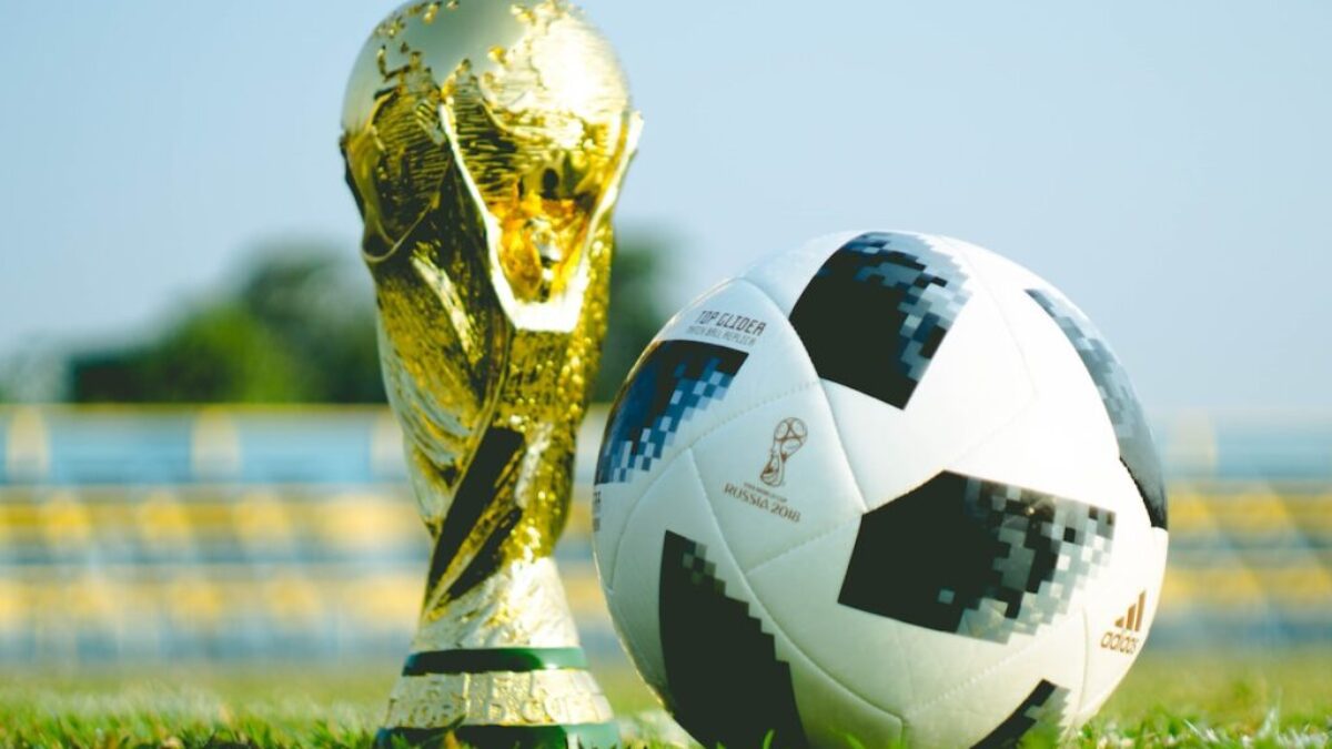 gold-colored trophy and soccerball