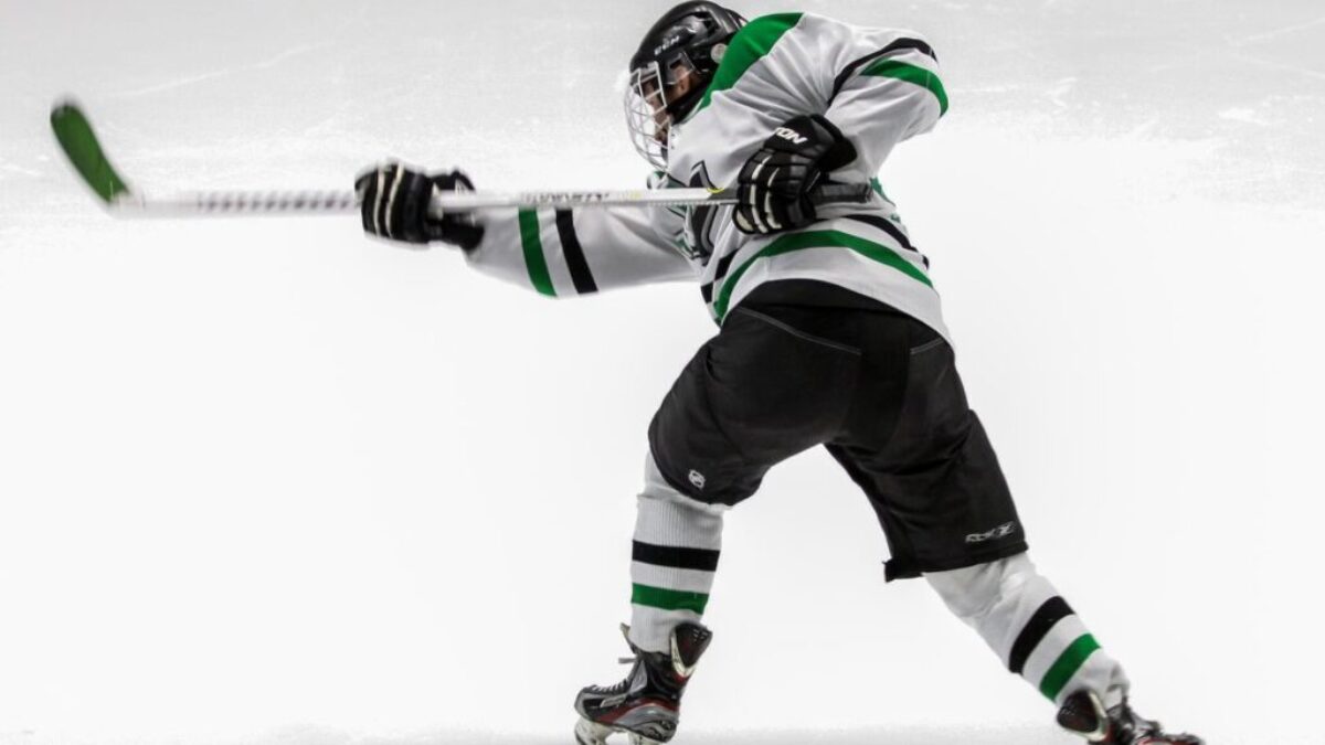 man wearing green and white ice hockey jersey while playing