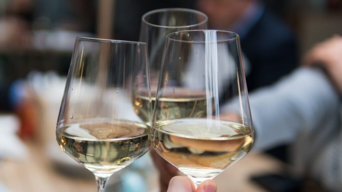 three people having a toast using three clear crystal wine glasses