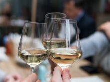 three people having a toast using three clear crystal wine glasses