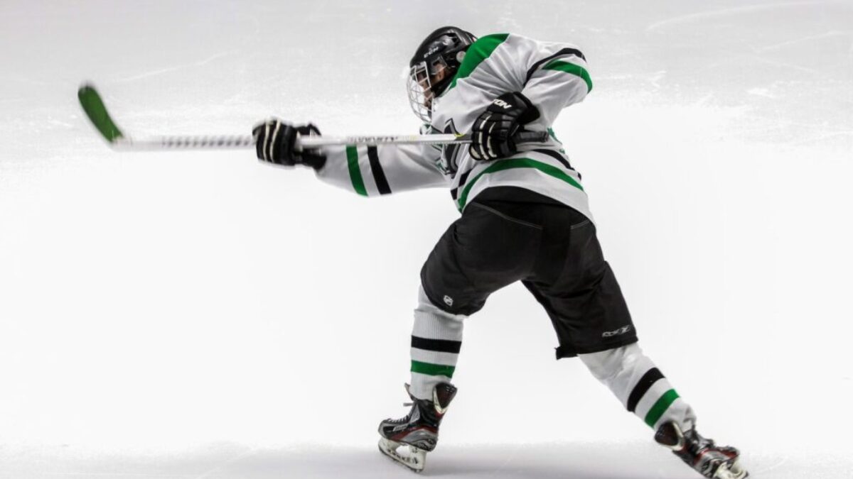 man wearing green and white ice hockey jersey while playing
