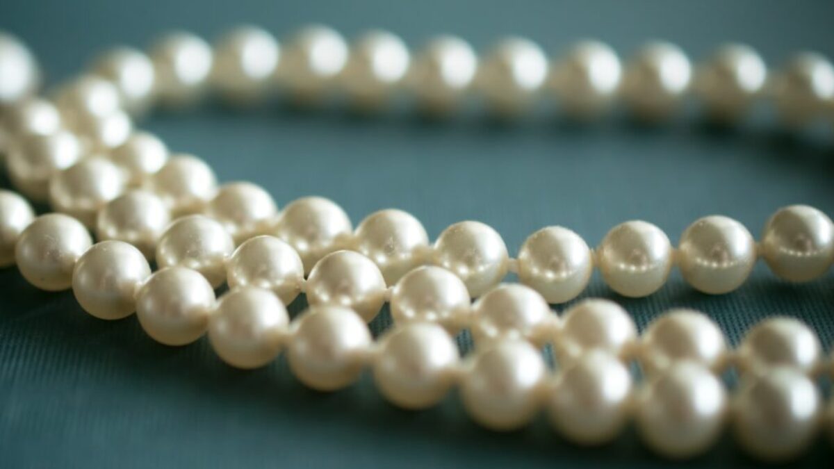 white pearl necklace on gray textile