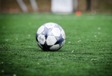 white and blue soccer ball on green grass field during daytime