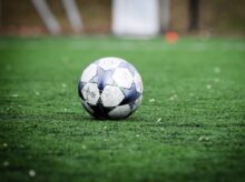 white and blue soccer ball on green grass field during daytime