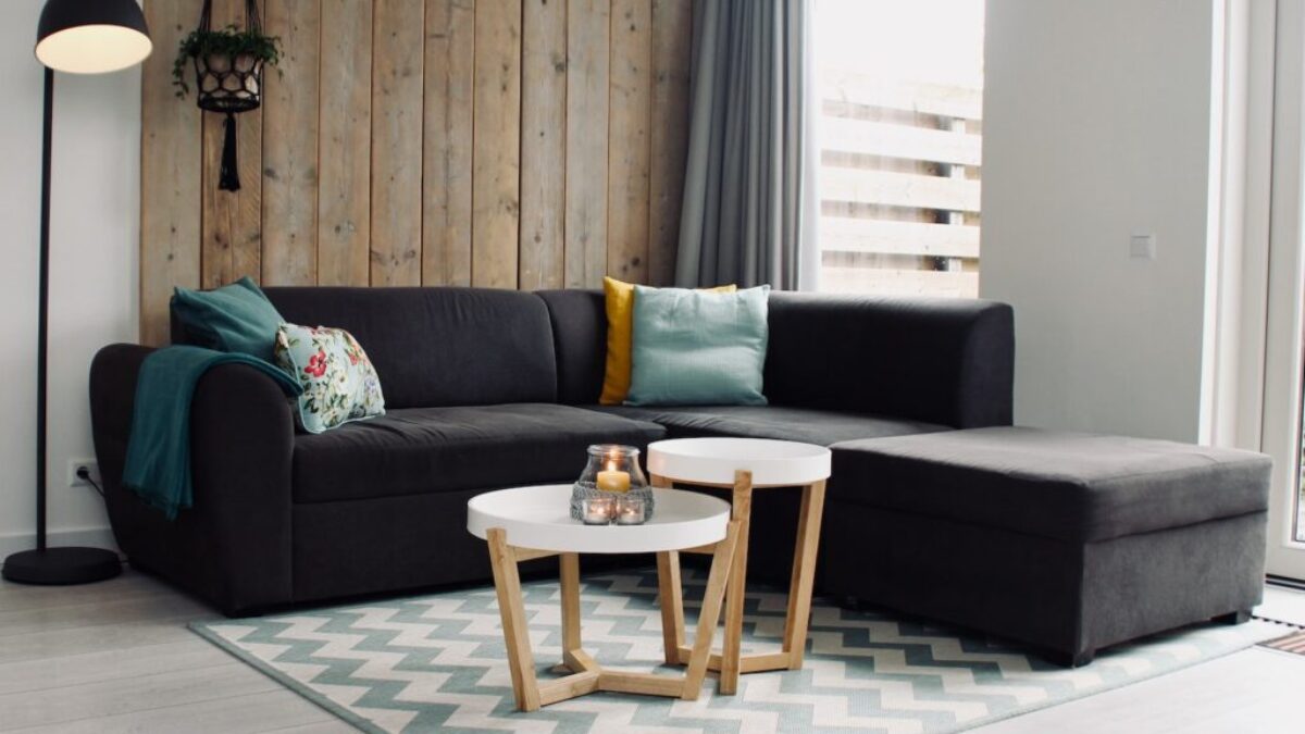 light candle on round white coffee table and sectional sofa