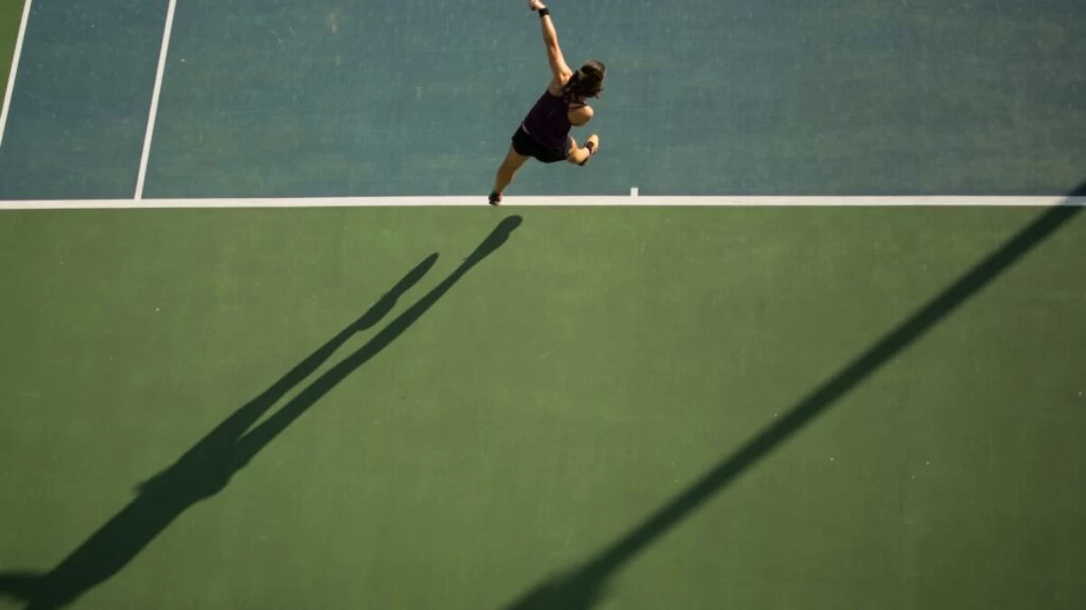 woman in black top holding tennis racket
