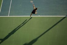 woman in black top holding tennis racket