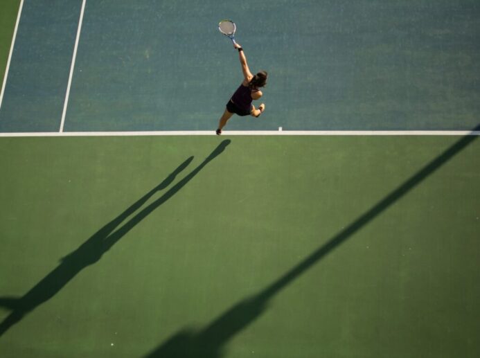 woman in black top holding tennis racket