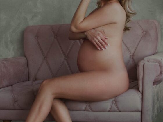 Naked Pregnant Woman Sitting on Pink Couch