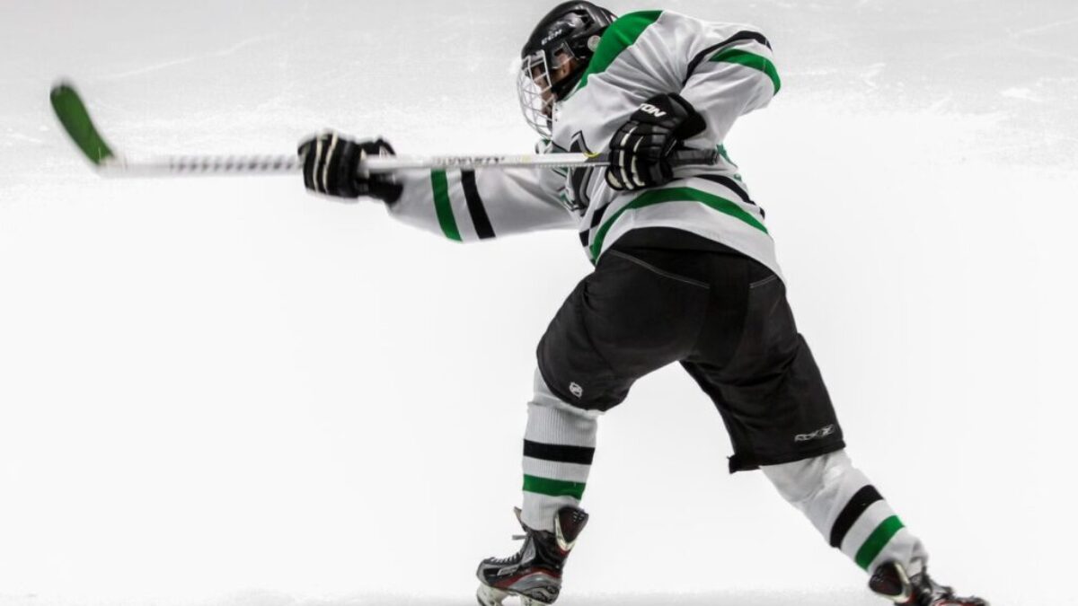 man wearing green and white ice hockey jersey while playing