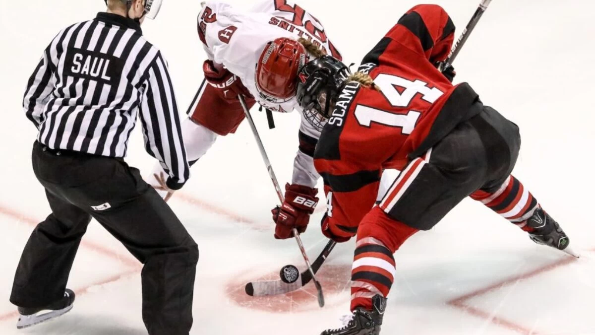 two persons playing ice hockey with referee