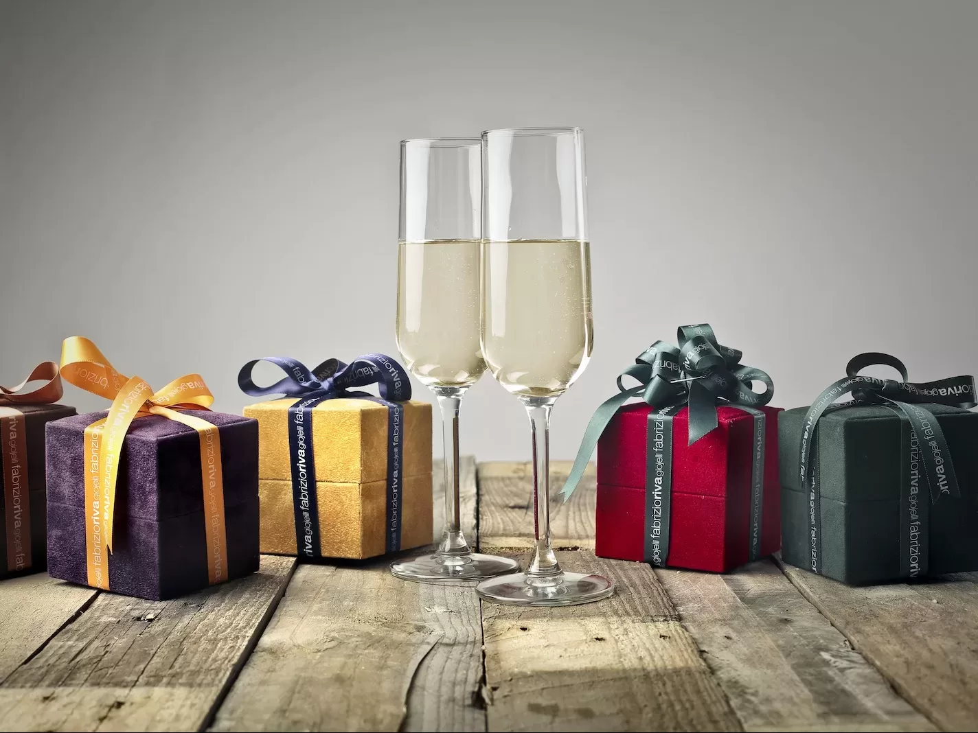 Five Assorted-color Gift Boxes and Two Footed Glasses on Top of Table