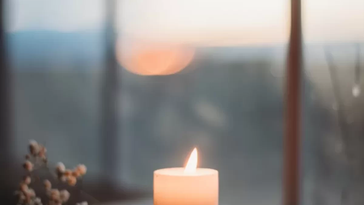 a lit candle sitting on top of a wooden table