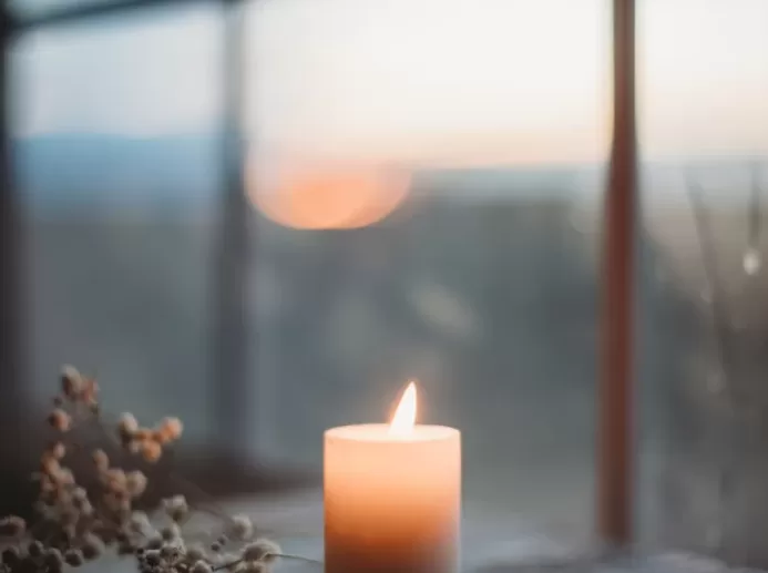 a lit candle sitting on top of a wooden table