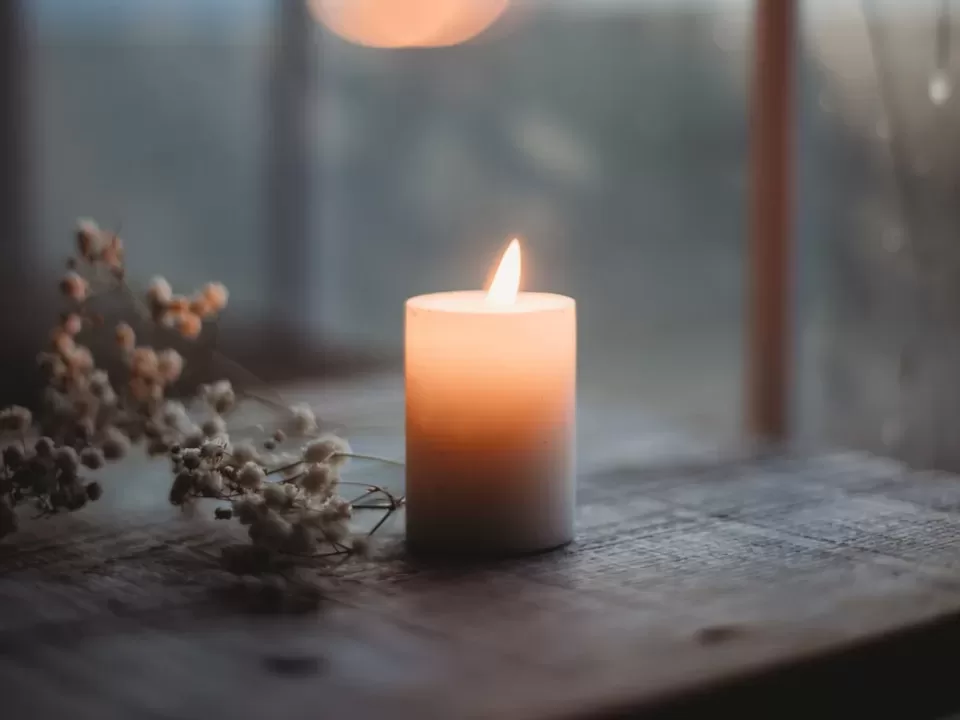 a lit candle sitting on top of a wooden table