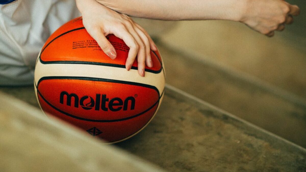 person holding red and white Molten basketball ball