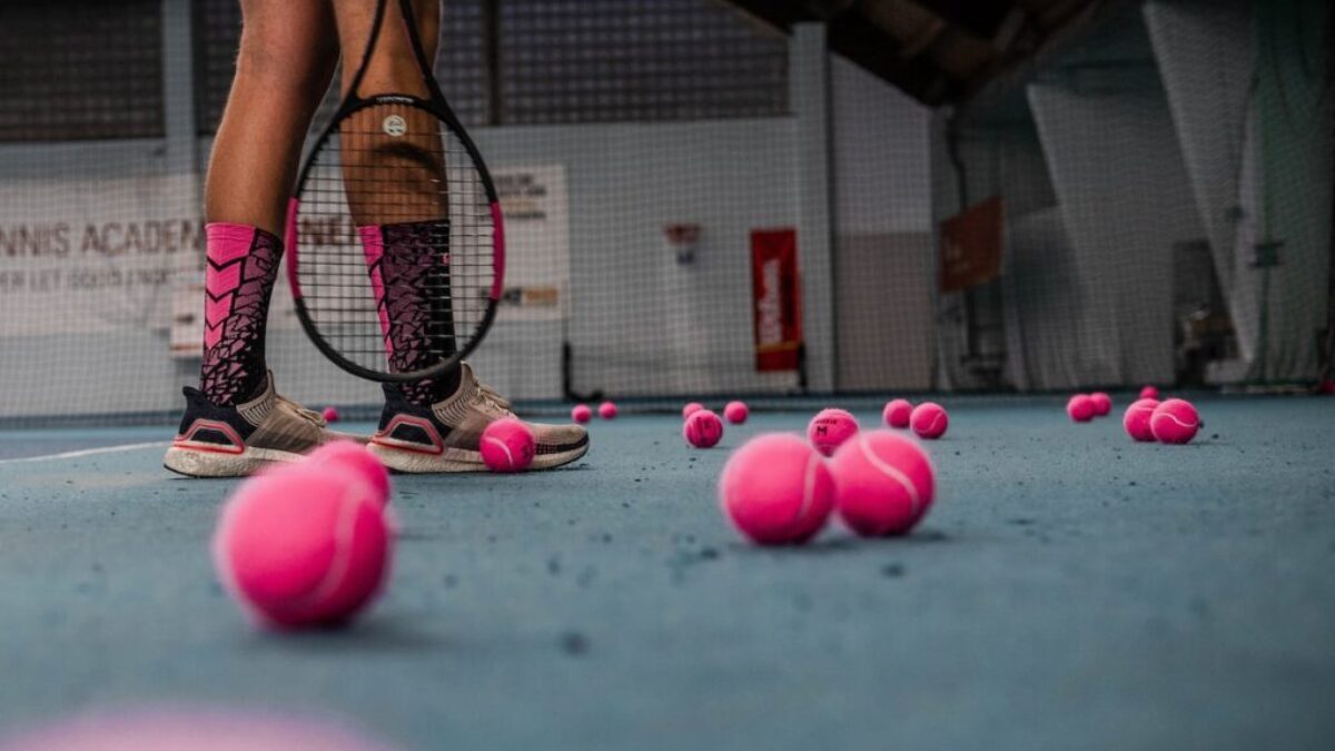 a person standing on a tennis court with a racket