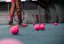 a person standing on a tennis court with a racket