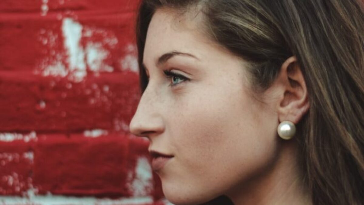 closeup photo of woman beside red painted wall