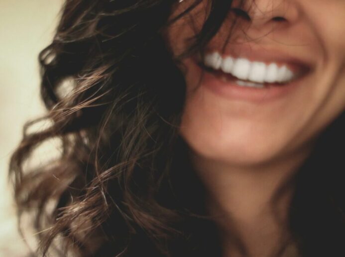 long black haired woman smiling close-up photography