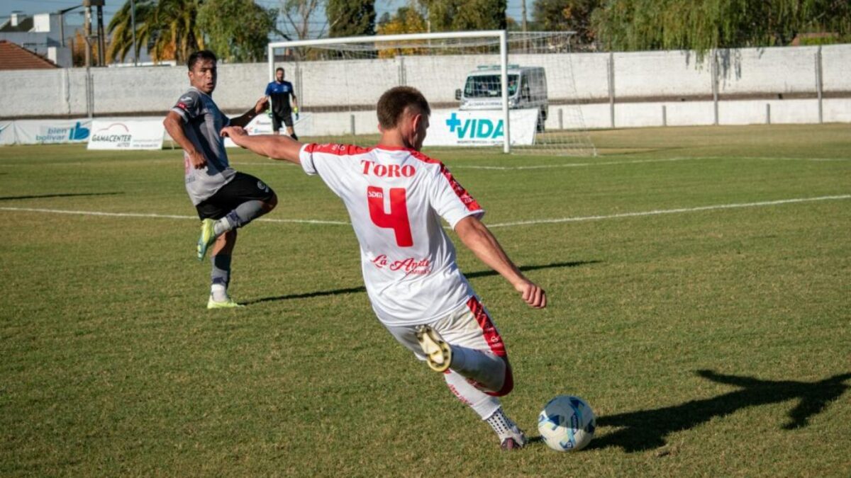 A soccer player is kicking the ball