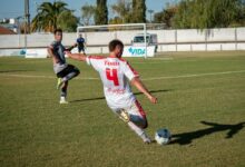 A soccer player is kicking the ball