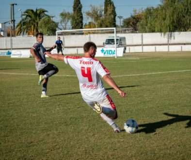 A soccer player is kicking the ball