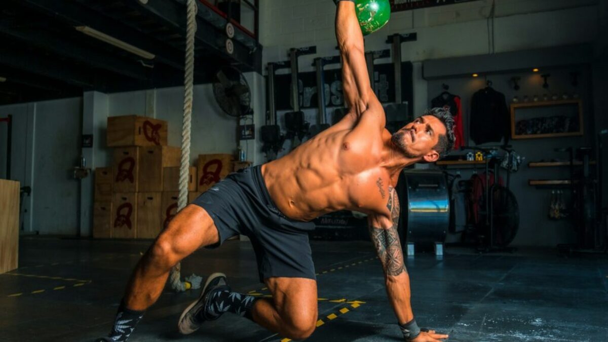 man in black shorts and black tank top doing push up