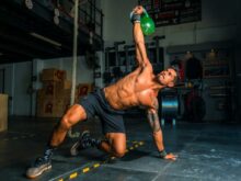man in black shorts and black tank top doing push up