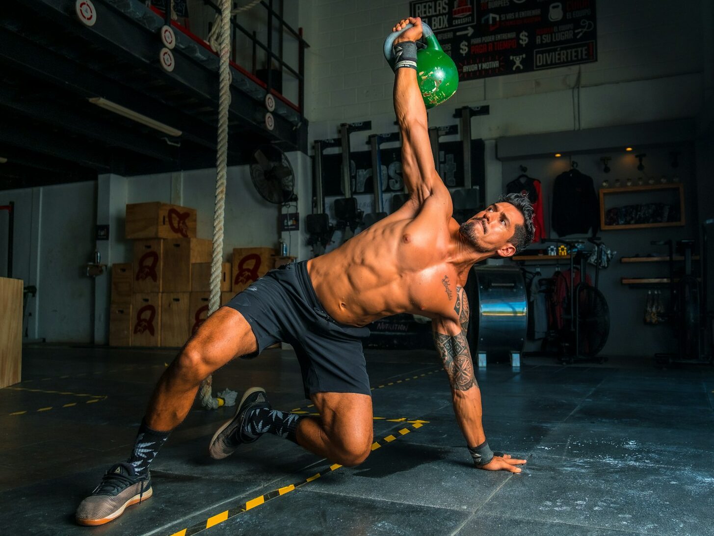 man in black shorts and black tank top doing push up