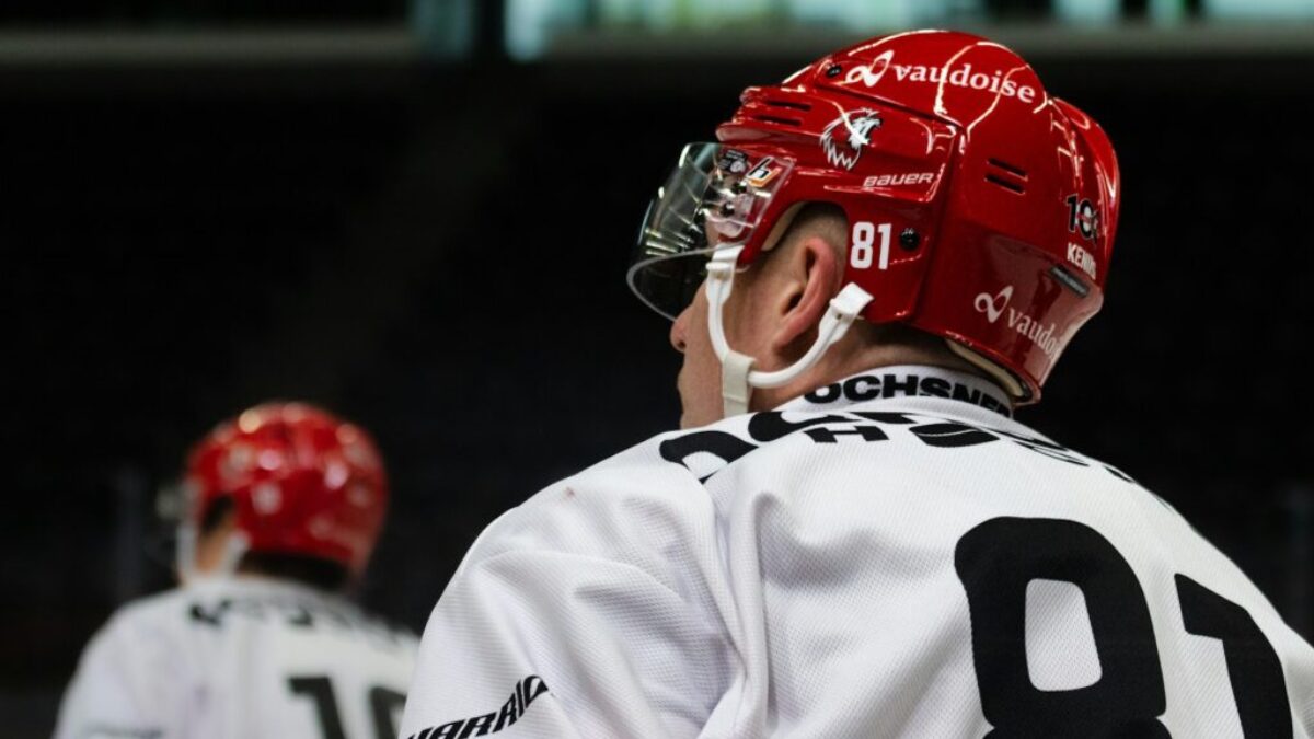 a hockey player wearing a red helmet and white jersey