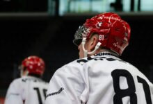 a hockey player wearing a red helmet and white jersey