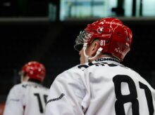 a hockey player wearing a red helmet and white jersey