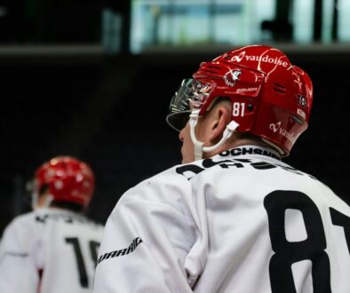 a hockey player wearing a red helmet and white jersey