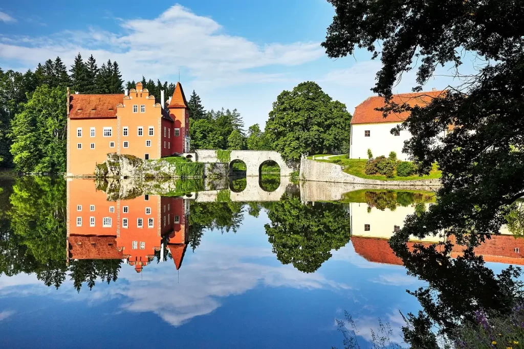 Jedinečnou památku dělá z Červené Lhoty její umístění na malém skalnatém ostrově uprostřed rybníka, ke kterému vede kamenný most. Zdroj: Shutterstock. - SportDeník Zámek Červená Lhota.