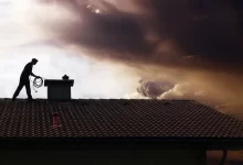 Kominík na střeše čistí komín