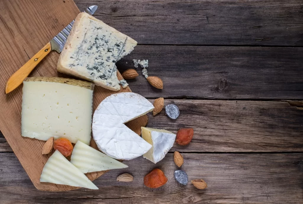 Different,Kinds,Of,Cheese,On,Old,Wooden,Table - SportDeník Různé druhy sýrů na prkénku