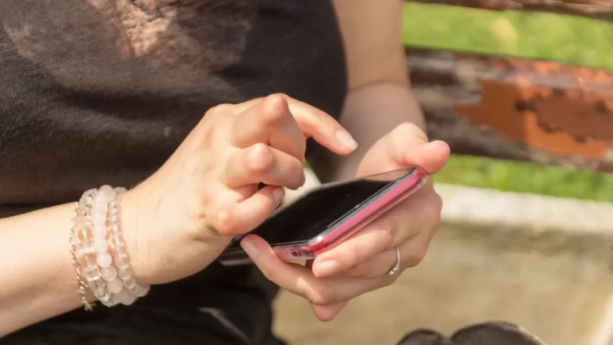Žena s revmatoidními uzly používá mobilní telefon