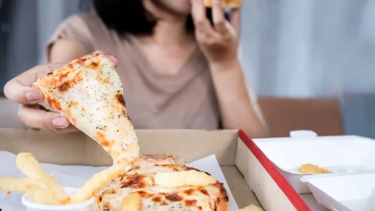 Žena, která v rychlosti konzumuje pizzu