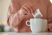 Žena louhující pytlík s čajem v hrnku