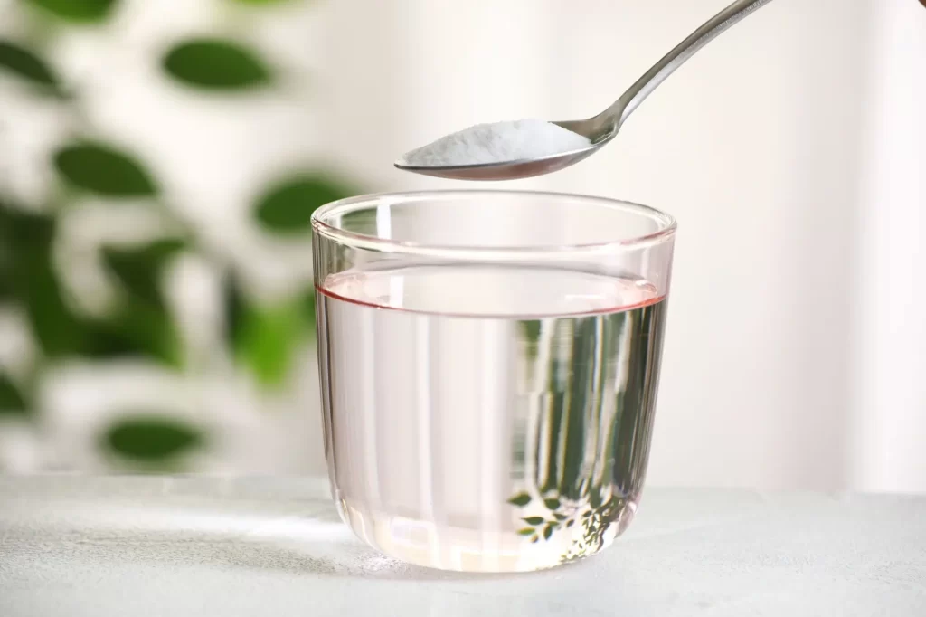 Shutterstock_2460213463 - SportDeník Jedlá soda na lžičce nad sklenkou vody