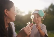 Žena s dítětem a s pampeliškou